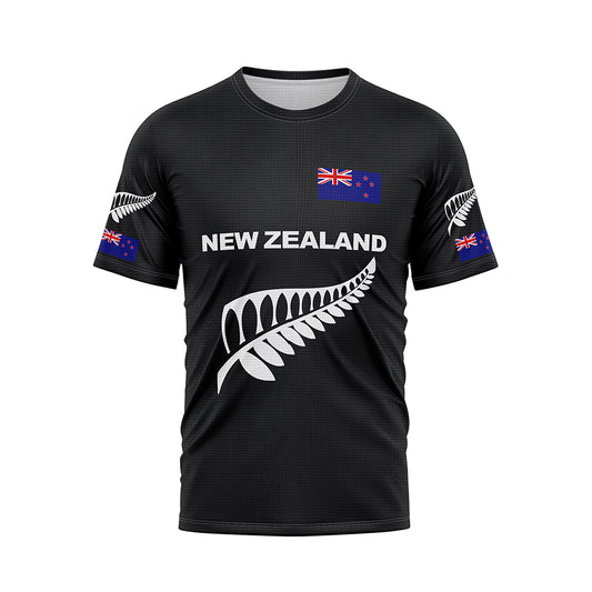 Front view of a black T-shirt featuring 'NEW ZEALAND' in white text across the chest, accompanied by a large white silver fern graphic below. A New Zealand flag is positioned on the upper right chest, and smaller silver ferns and flags are on both sleeves.