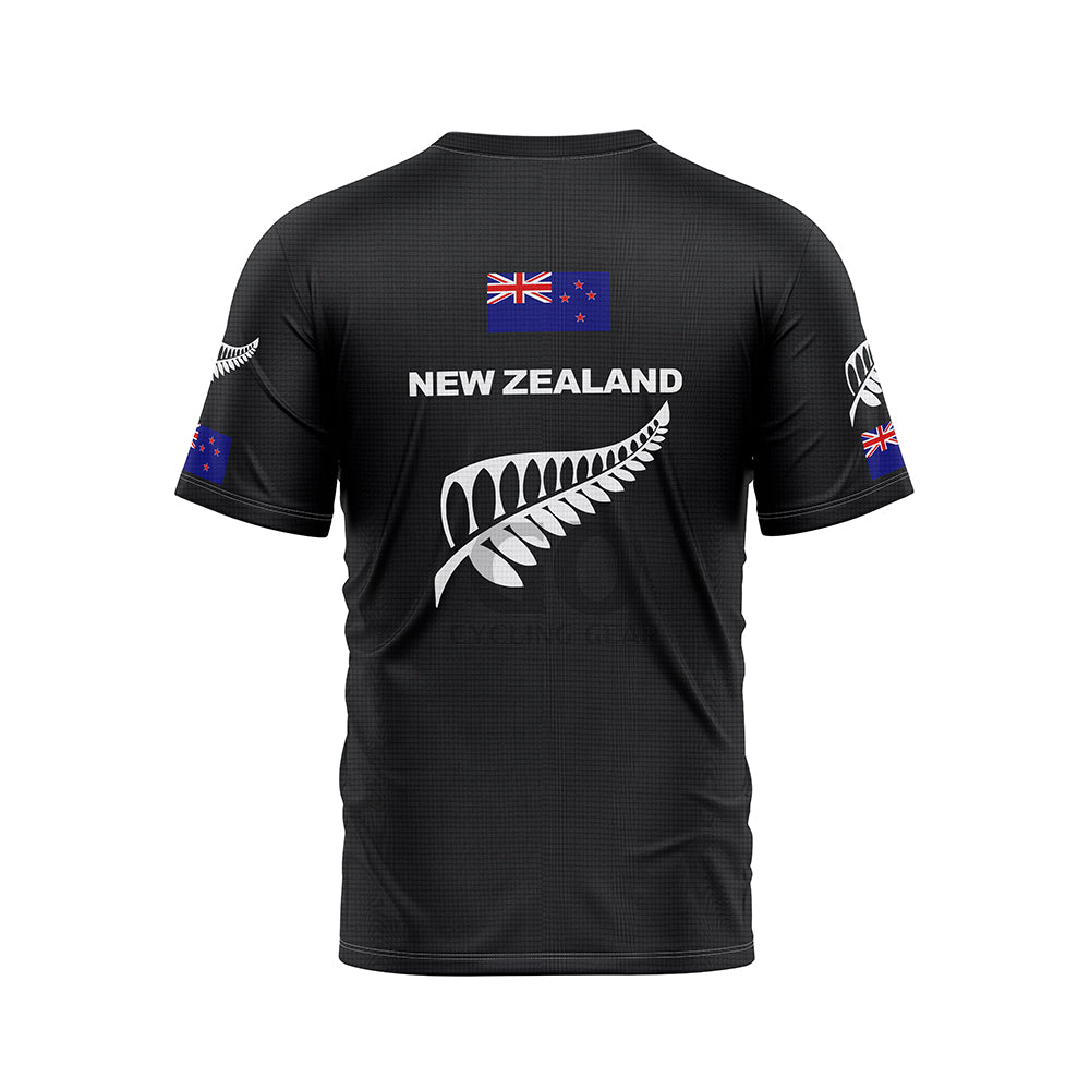 Back view of a black T-shirt featuring 'NEW ZEALAND' in white text across the upper back, with a large white silver fern graphic below. A New Zealand flag is positioned on the upper back, and smaller silver ferns and flags are on both sleeves.