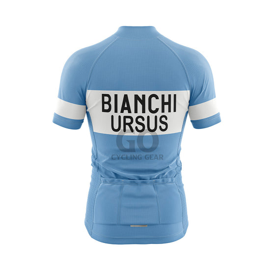 Back view of a light blue short-sleeved cycling jersey. A wide white horizontal band across the upper back features "BIANCHI" in large black capitalized letters, with "URSUS" in black capitalized letters directly below it. Three pockets are visible on the lower back, and the sleeves display white bands with "BIANCHI" in black text.